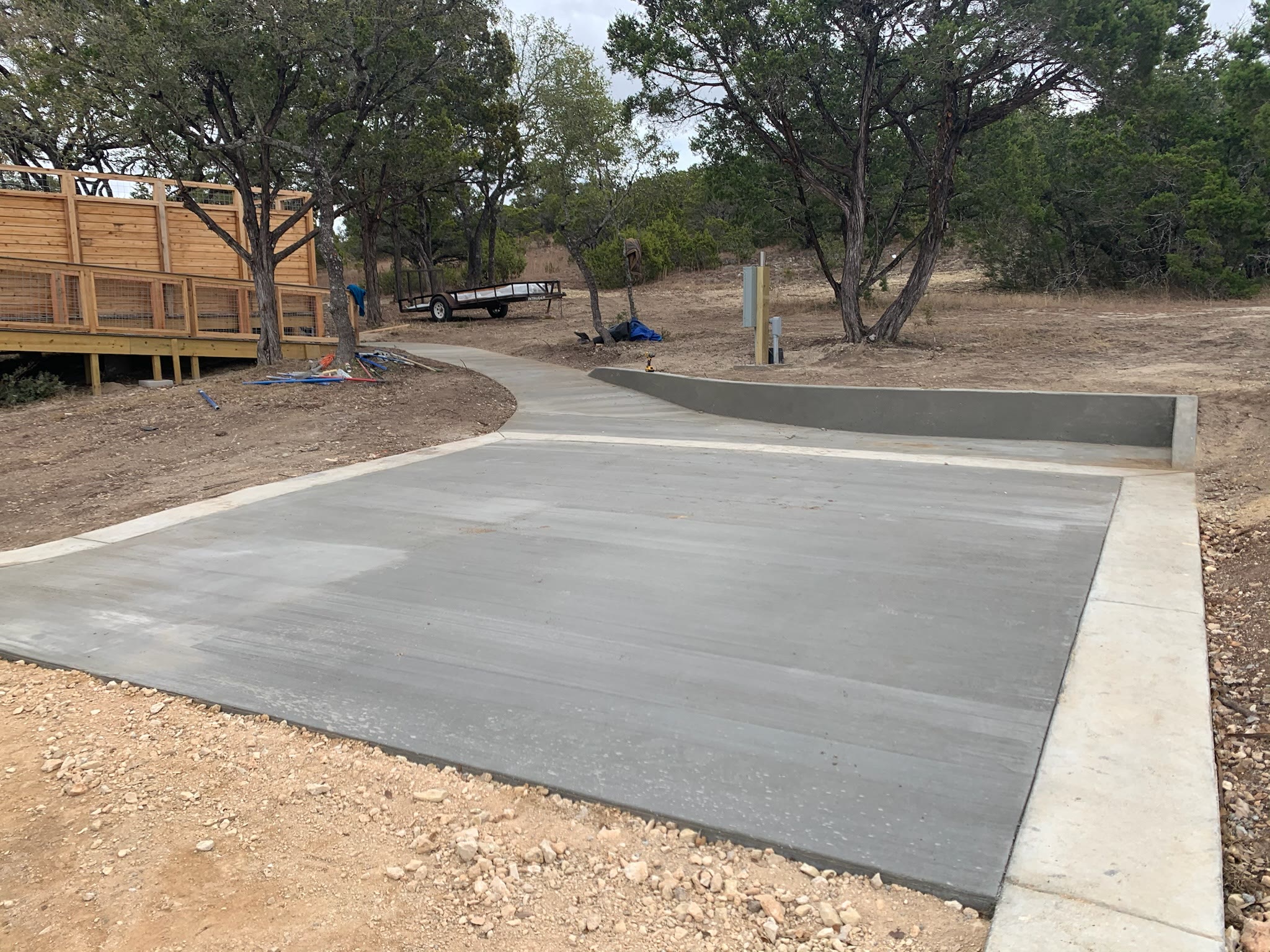 Finished concrete pad and curved walkway with retaining curb