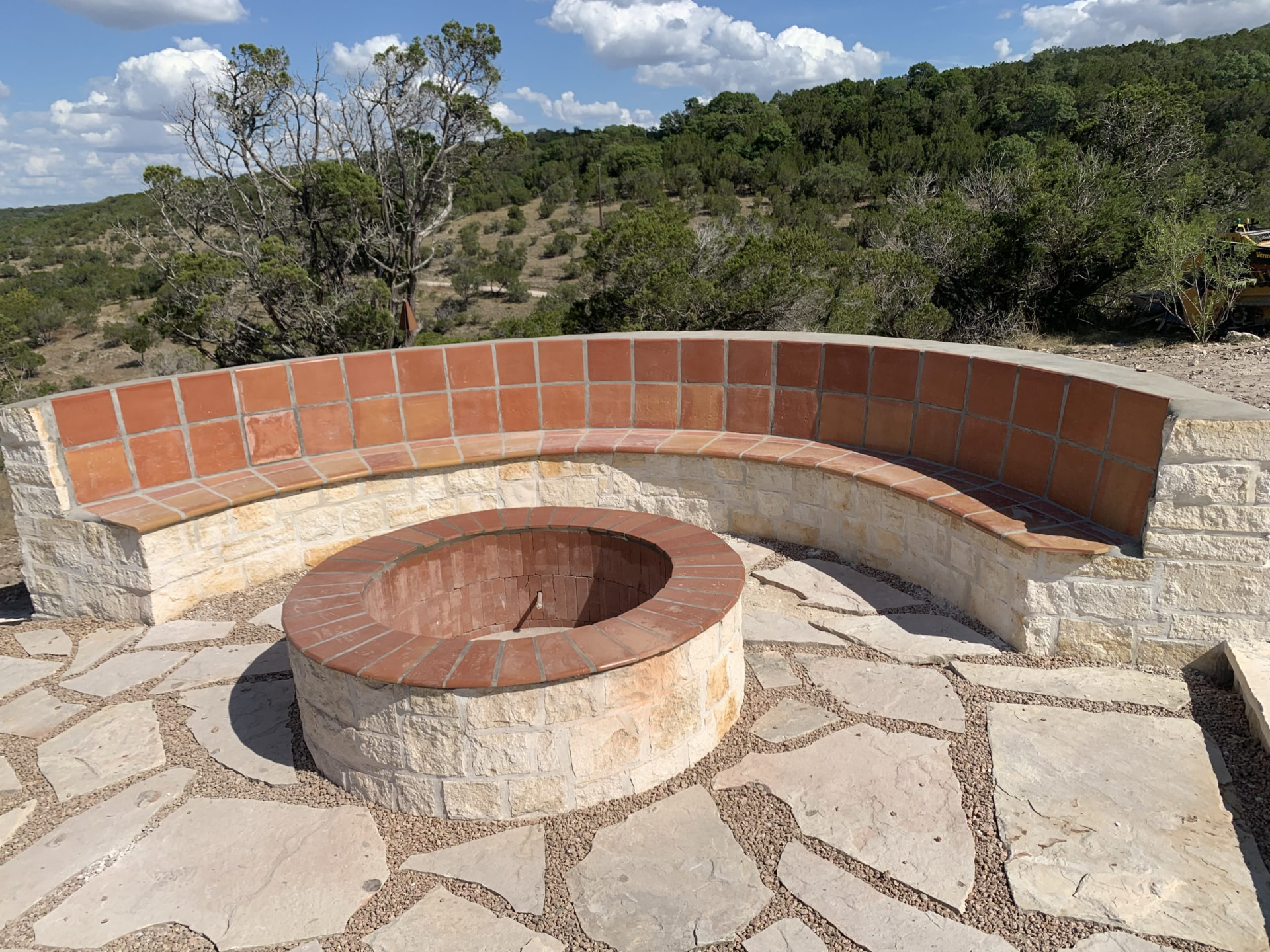 Curved limestone fire pit with saltillo tile bench overlooking the Hill Country